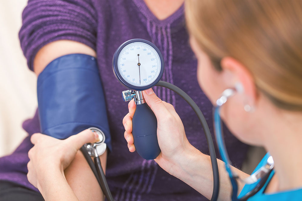 Hypertension care high blood pressure elderly rehabilitation Brooklyn, NYC. Nurse checking blood pressure of a patient to prevent the complications of a stroke.