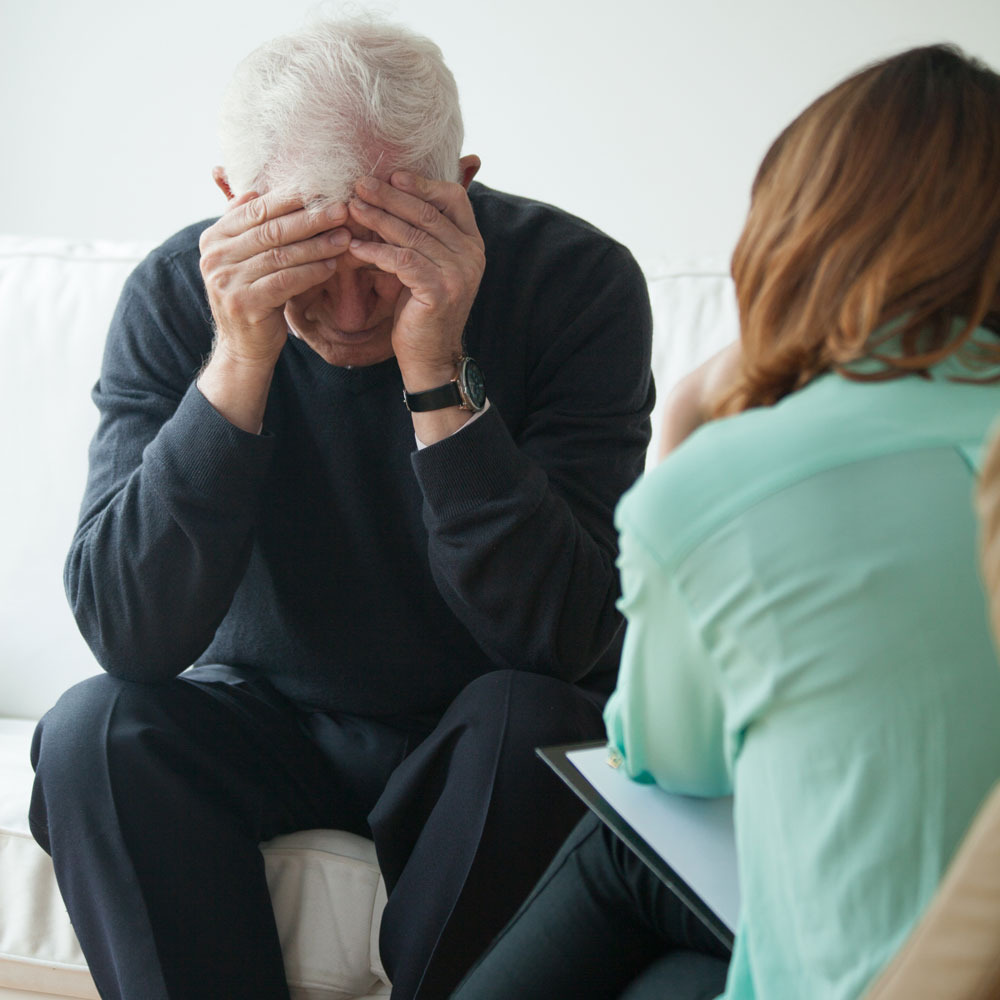 Nurse helping elderly patient with neurological diseases by psychological therapies