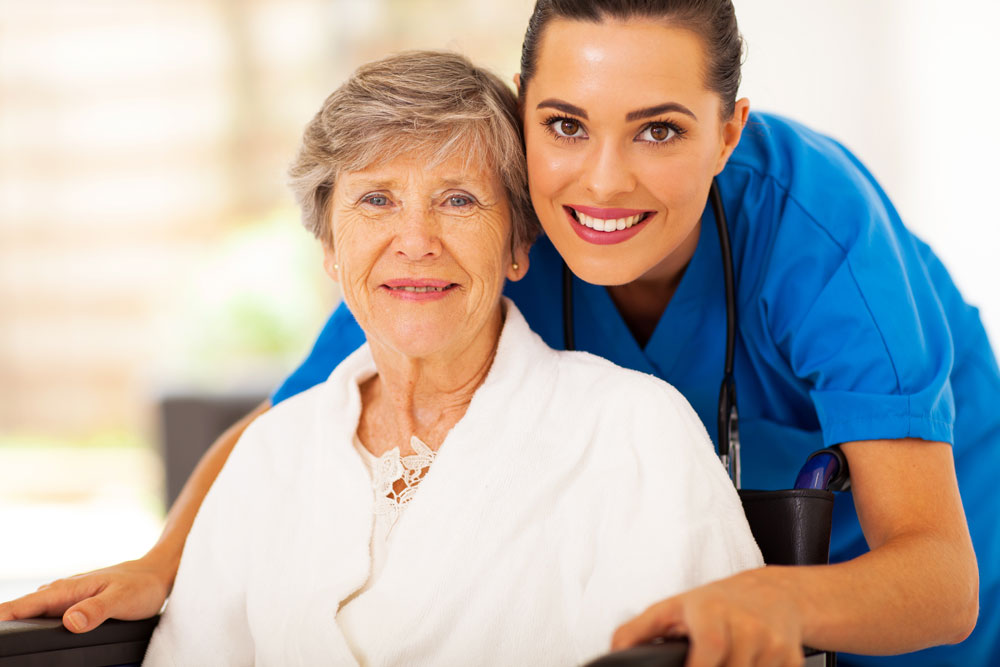 Nursing care at Haym Salomon Nursing Home in Brooklyn, New York. Happy senior woman with wound infection sitting on a wheelchair with caregiver .