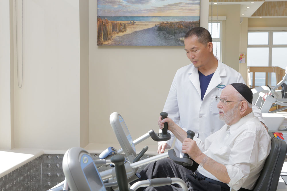 An elderly patient getting exercise as a part of cardiac rehabilitation to strengthen the heart at Haym Salomon Home For Nursing & Rehabilitation