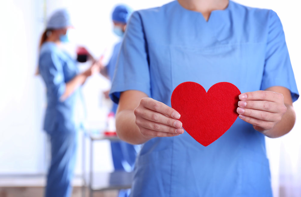 doctor holding red heart at hospital for wound care awareness
