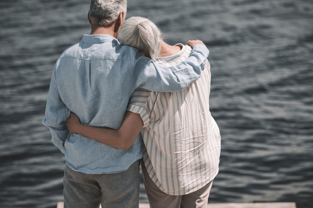 Senior couple walking on beach to overcome shortness of breath