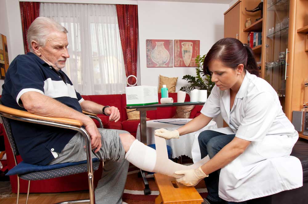 Nurse applying bandage to elderly patient to help wounds heal faster