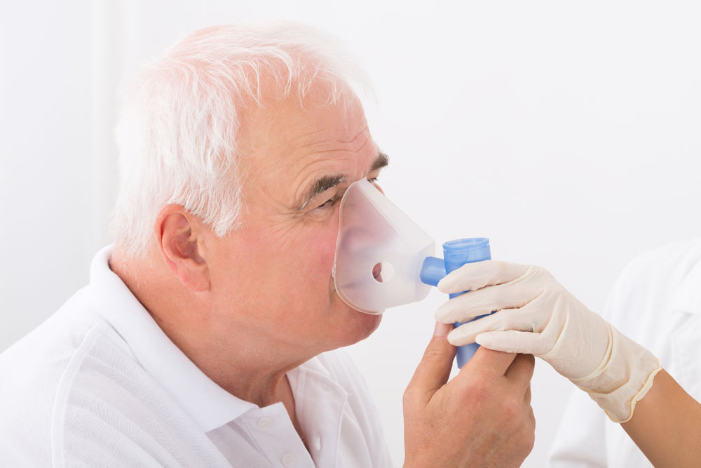 Elderly man suffering from COPD (Chronic obstructive pulmonary disease) using oxygen mask