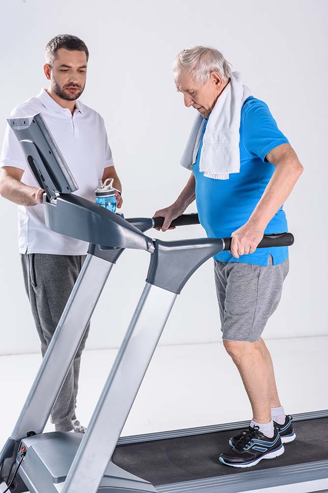 Elderly man working out on treadmill during pulmonary rehab session
