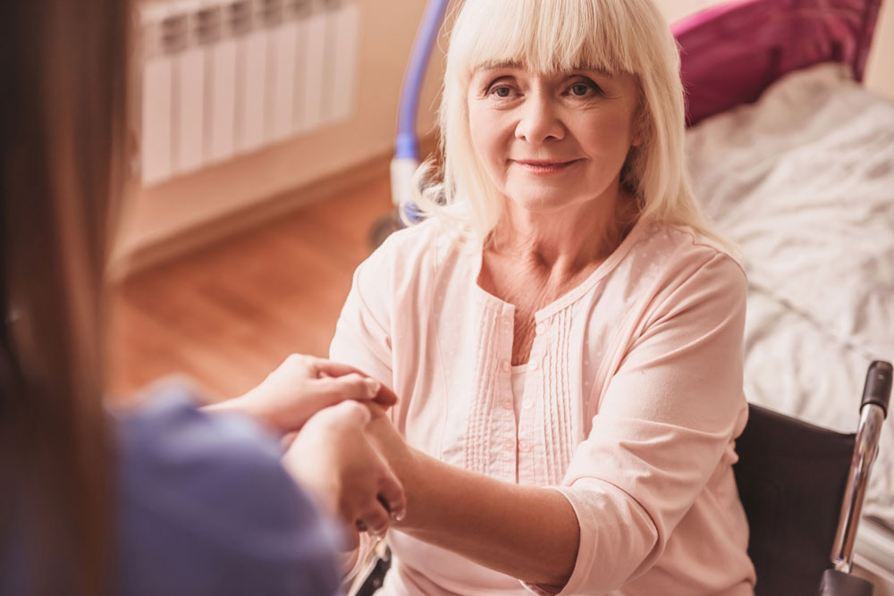 Beautiful old lady holding doctors hand and getting speech disorder therapy