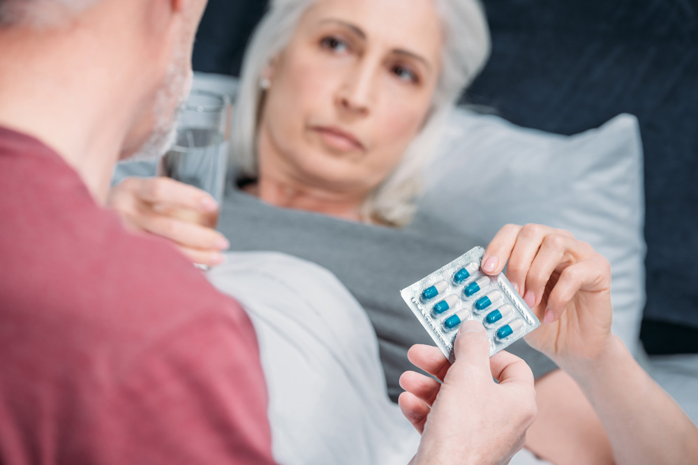 Doctor giving medicine to elderly woman suffering from Cardiorenal Syndrome