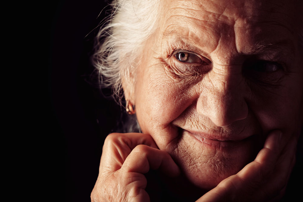 Portrait of a senior woman on black background who is a part of Neurological Rehab program