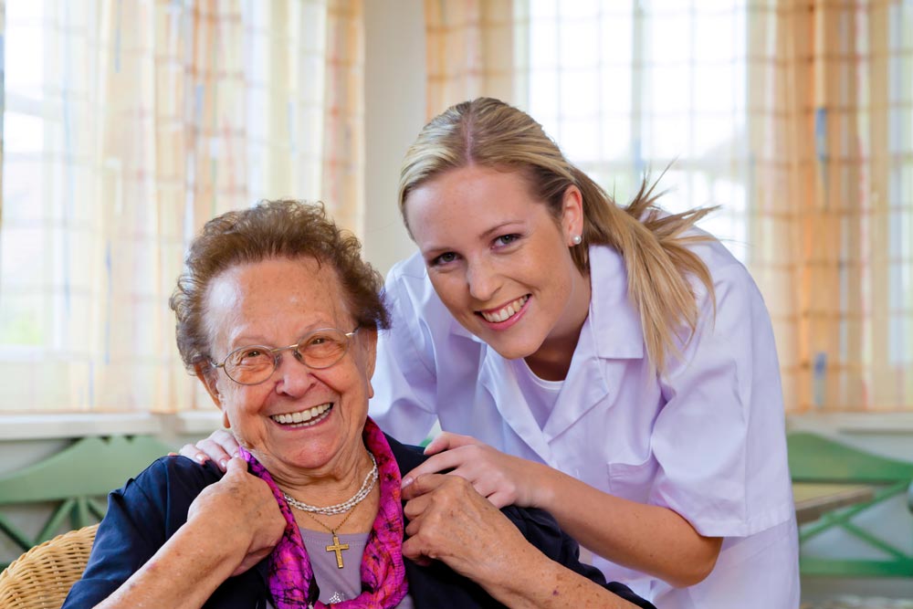 Young female nurse providing leisure activities to an elderly woman