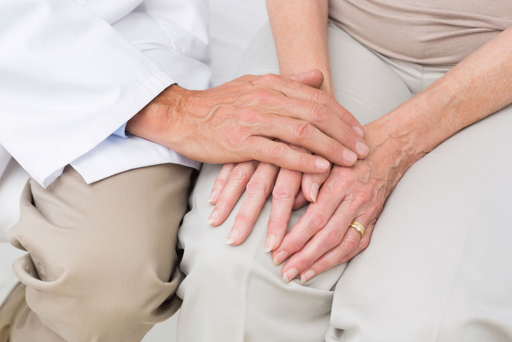 Nurse holding hands of a woman living with ileostomy