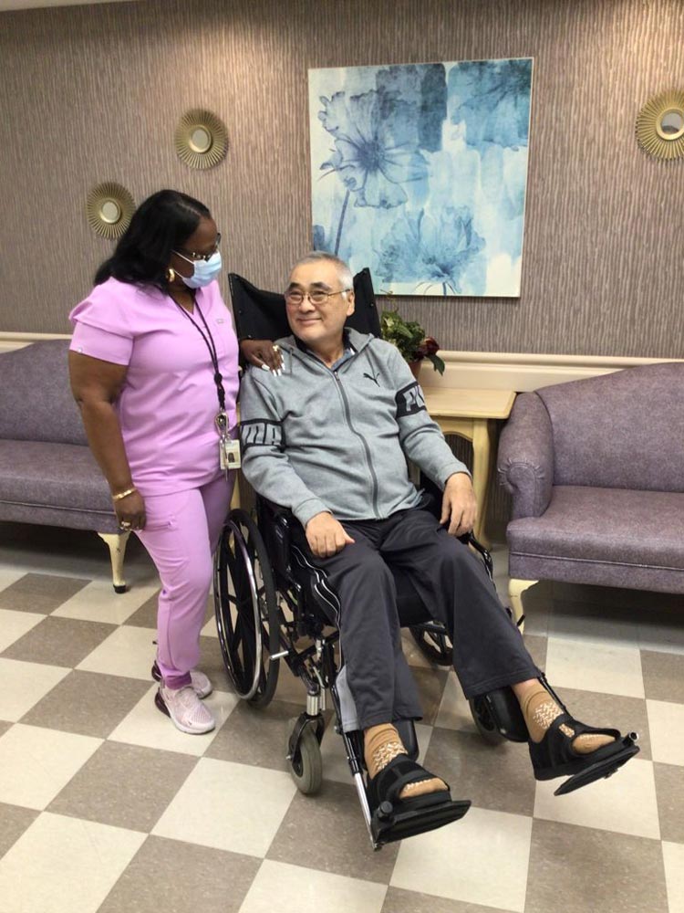 Nurse taking care of an elderly man on wheel chair healing after heart attack & arthritis.