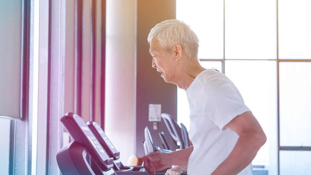 Senior asían man doing exercise on treadmill to cope with neurological diseases.