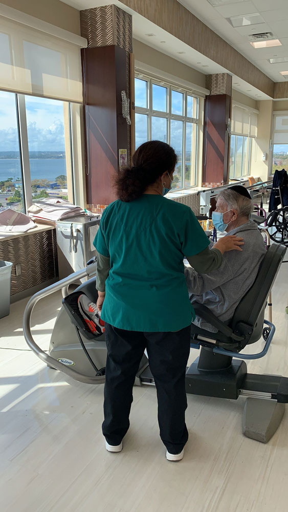 Physical therapist helping senior man in doing exercise for short-term-rehab