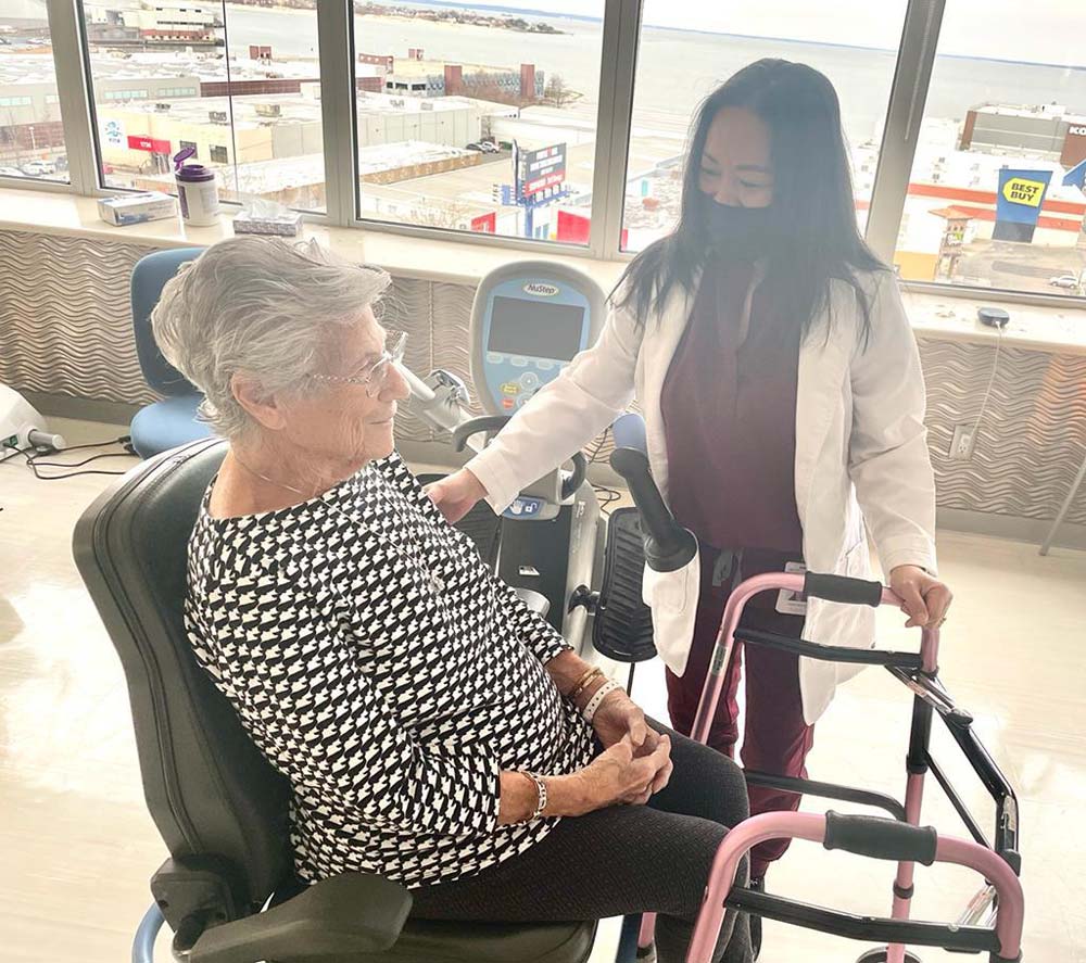 Female therapist helping senior woman with therapy for stroke recovery