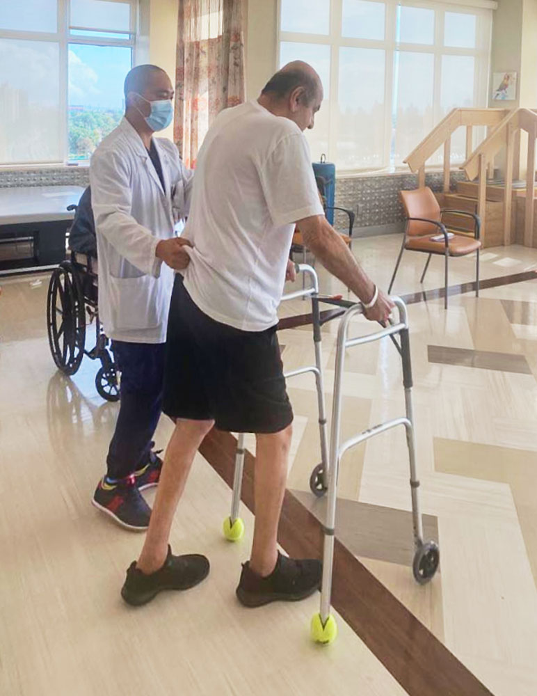 Physical therapist helping senior man with walking problems after stroke.