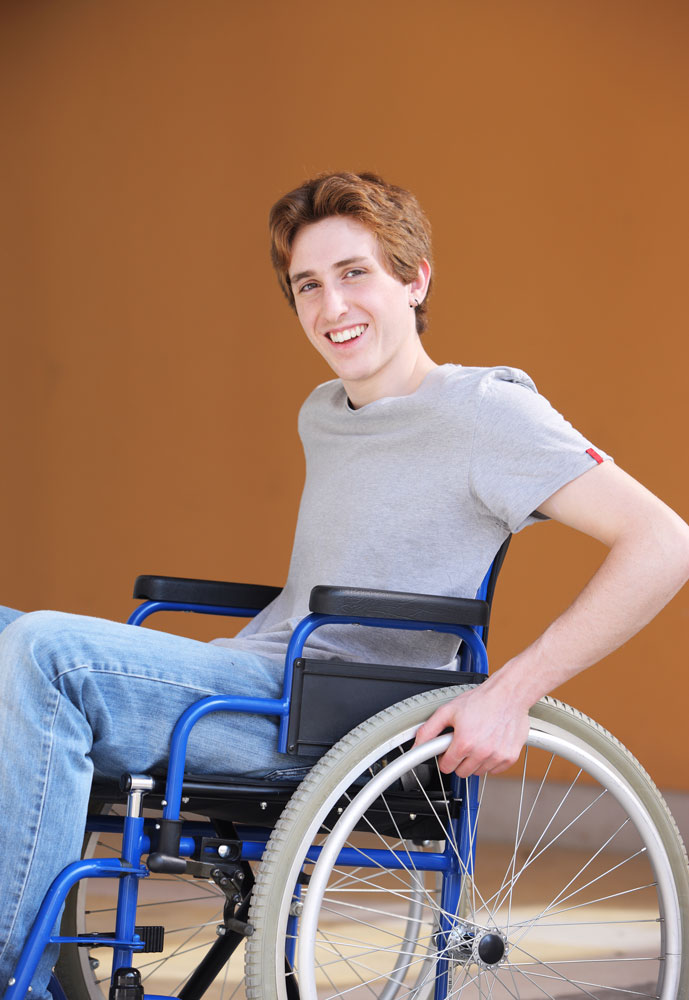 Disabled young man smiling sitting on a wheel chair suffering from sports injury