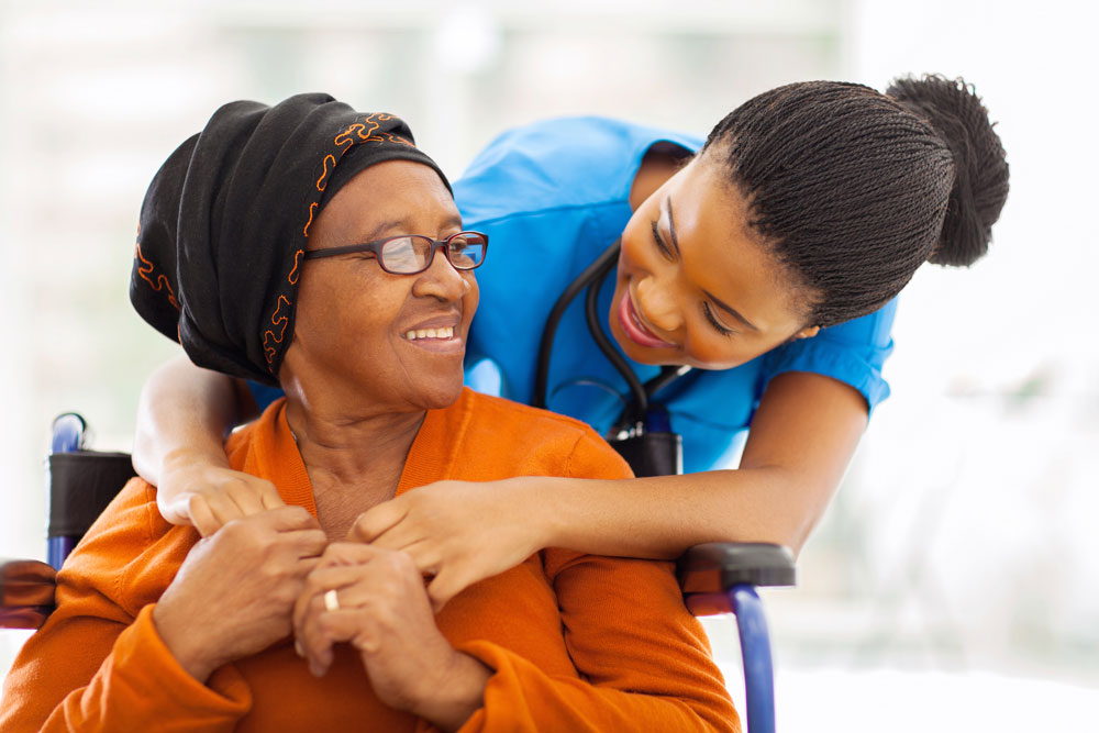 African senior patient suffering from Parkinson's enjoying recreational activities with female nurse to slow down Parkinson's.