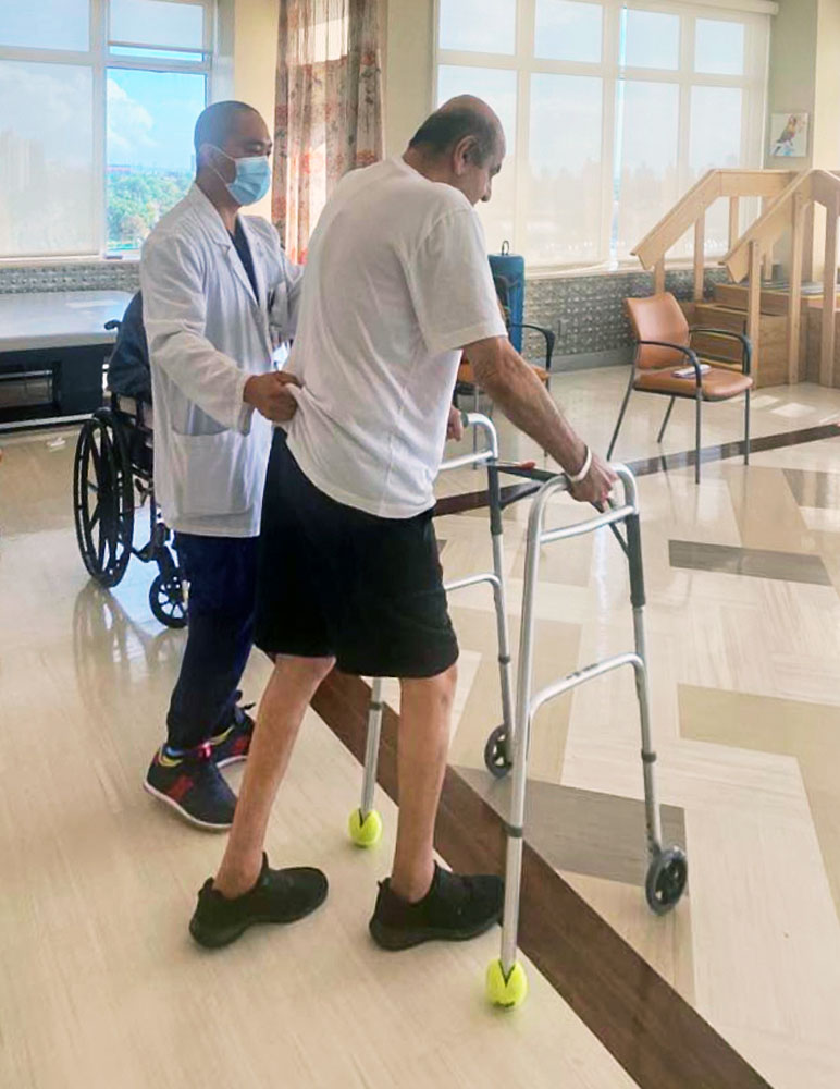 Physical therapist helping senior man to walk using support to recover from balance problems.