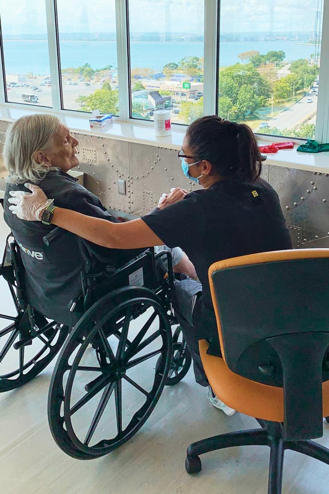 Nurse taking care of an elderly woman sitting on a wheelchair suffering from causes of sudden decline in Parkinson's.