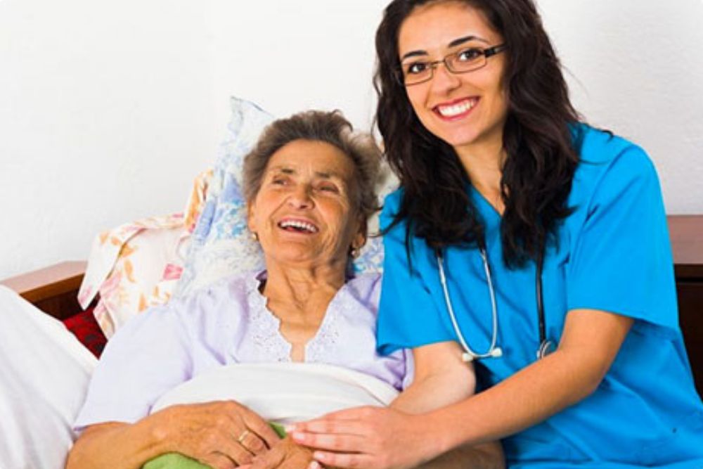 Nurse taking care of senior woman lying on bed suffering from sudden extreme fatigue.