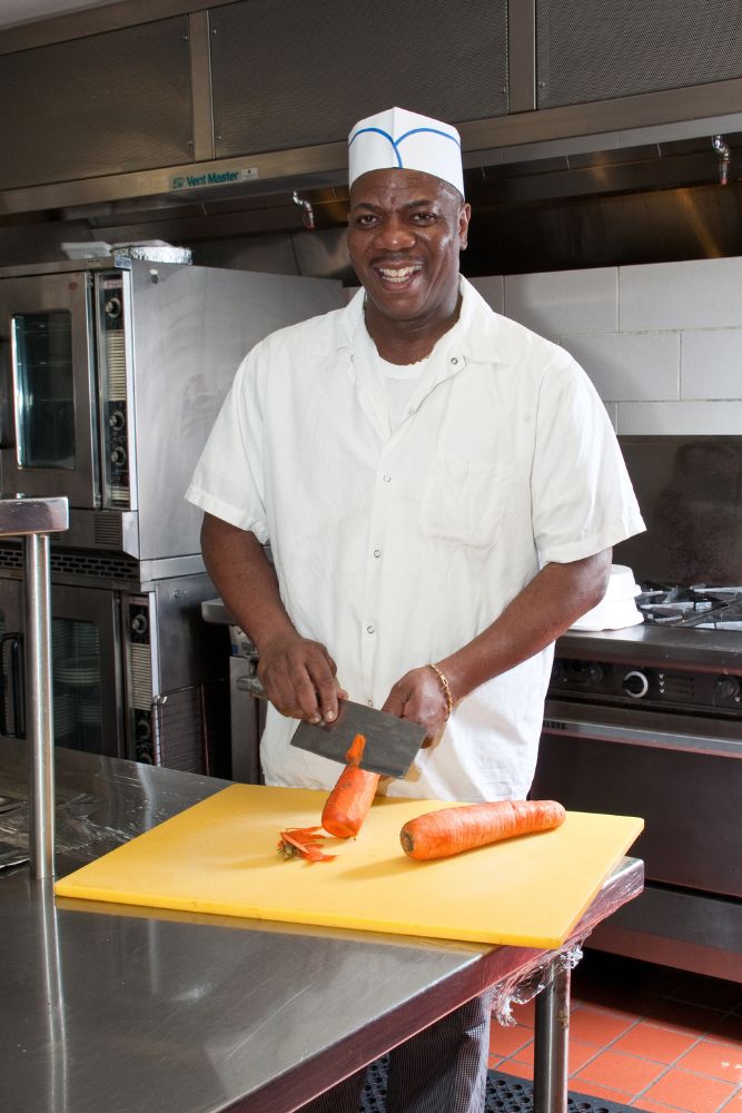 Chef chopping carrots to cook the food that eliminates excess mucus.