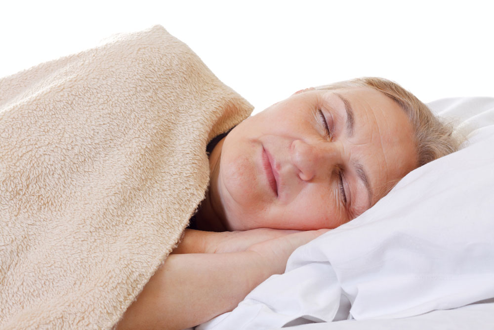 Elderly woman sleeping suffering from sleep apnea and sleepiness symptoms.