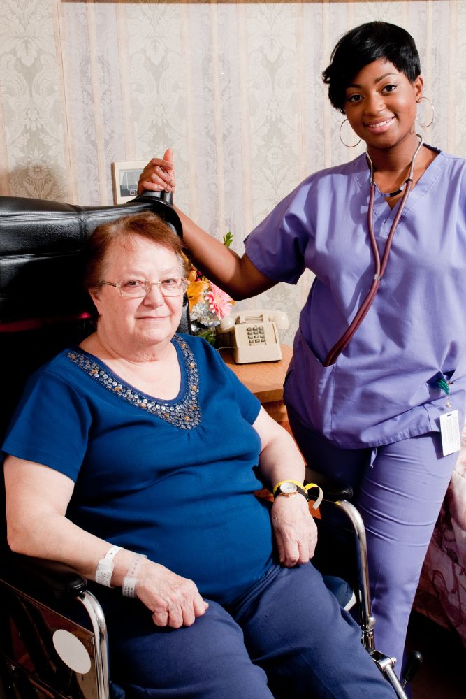 Nurse standing alongside an elderly woman suffering from Neurological Conditions Caused by Hypothyroidism