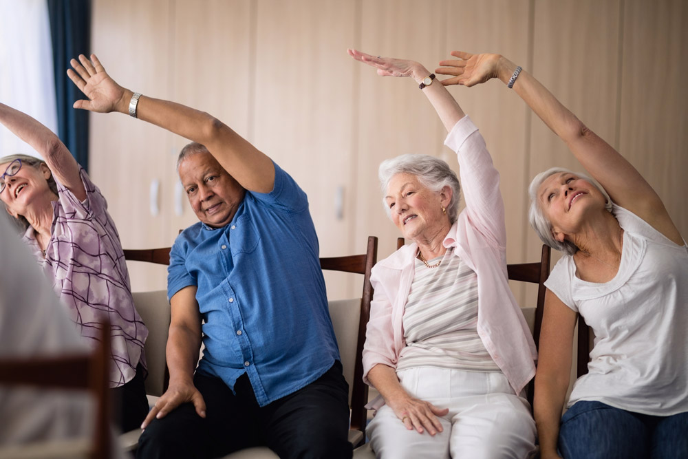 Senior people doing chair yoga to improve neurological problems.