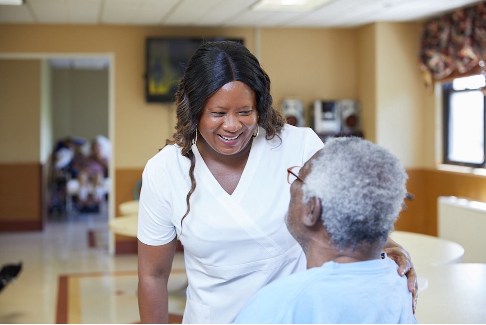 Comfort Care Caregiver providing Comfort Care to an elderly resident in a senior living community, offering compassionate support, reassurance, and personalized attention.